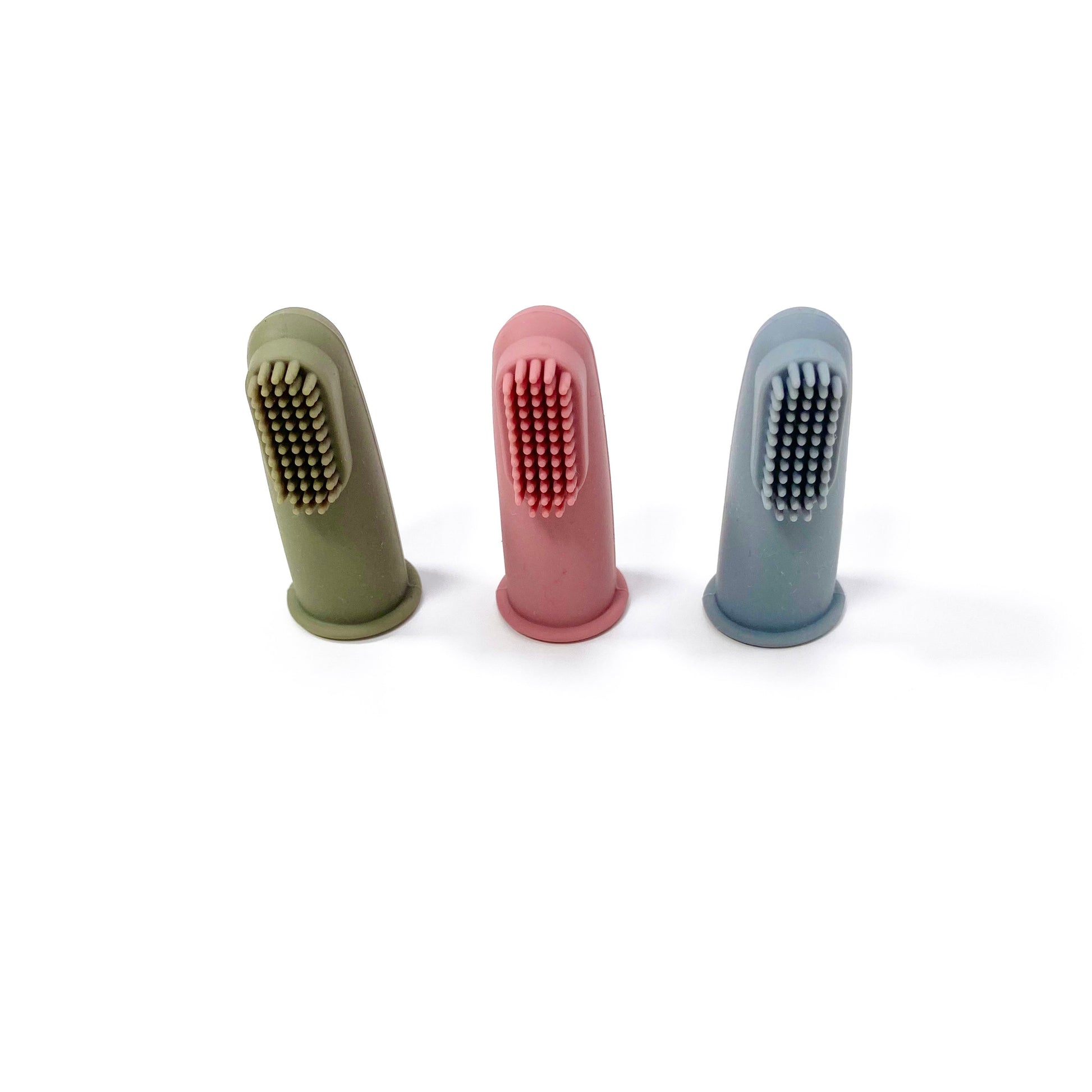 A set of silicone baby toothbrushes in colours khaki green, rose pink and ocean blue. Image shows the toothbrushes standing up, in a line.