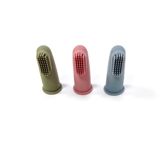 A set of silicone baby toothbrushes in colours khaki green, rose pink and ocean blue. Image shows the toothbrushes standing up, in a line.