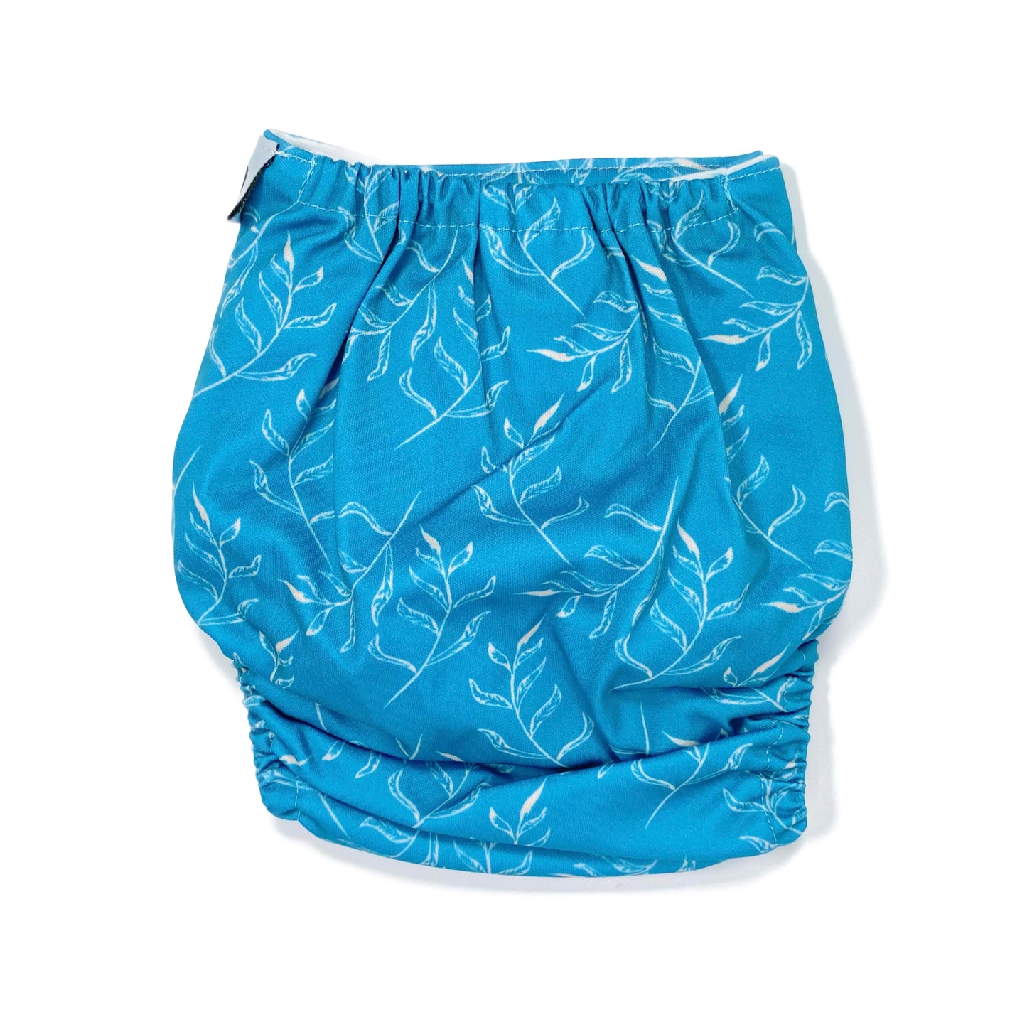 An adjustable reusable nappy for babies and toddlers, featuring a blue fern design, with images of white fern leaves on a blue background. View shows the back of the nappy.