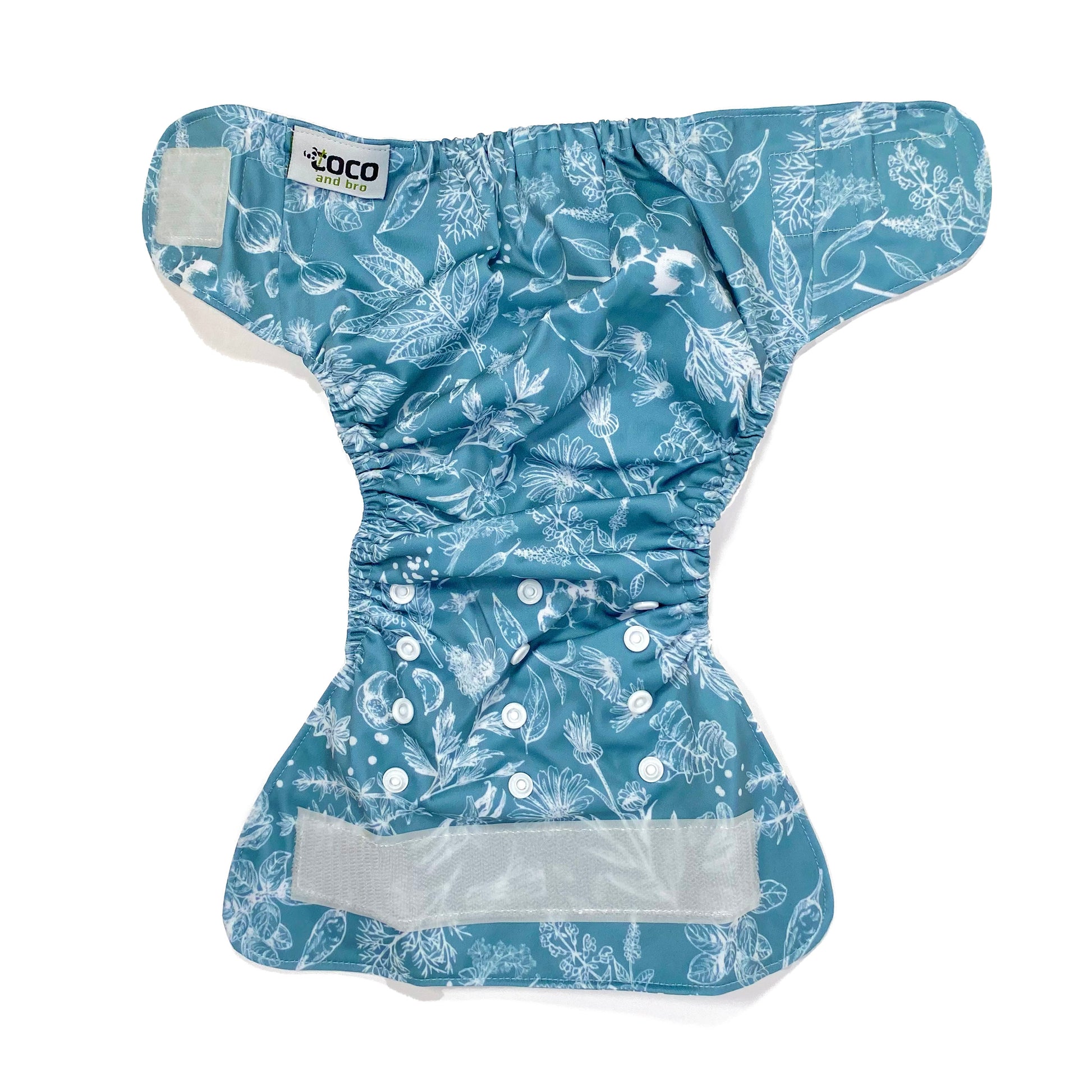 An adjustable reusable nappy for babies and toddlers, featuring a blue harvest design, with white images of various crops on a blue background. View shows the full outside pattern of the nappy, with fastenings open.