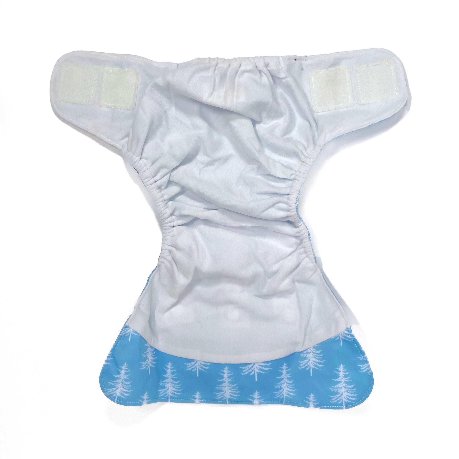 An adjustable reusable nappy for babies and toddlers, featuring a cool blue pine design design, with images of white pine trees on a blue background. View shows the inside fabric of the nappy.
