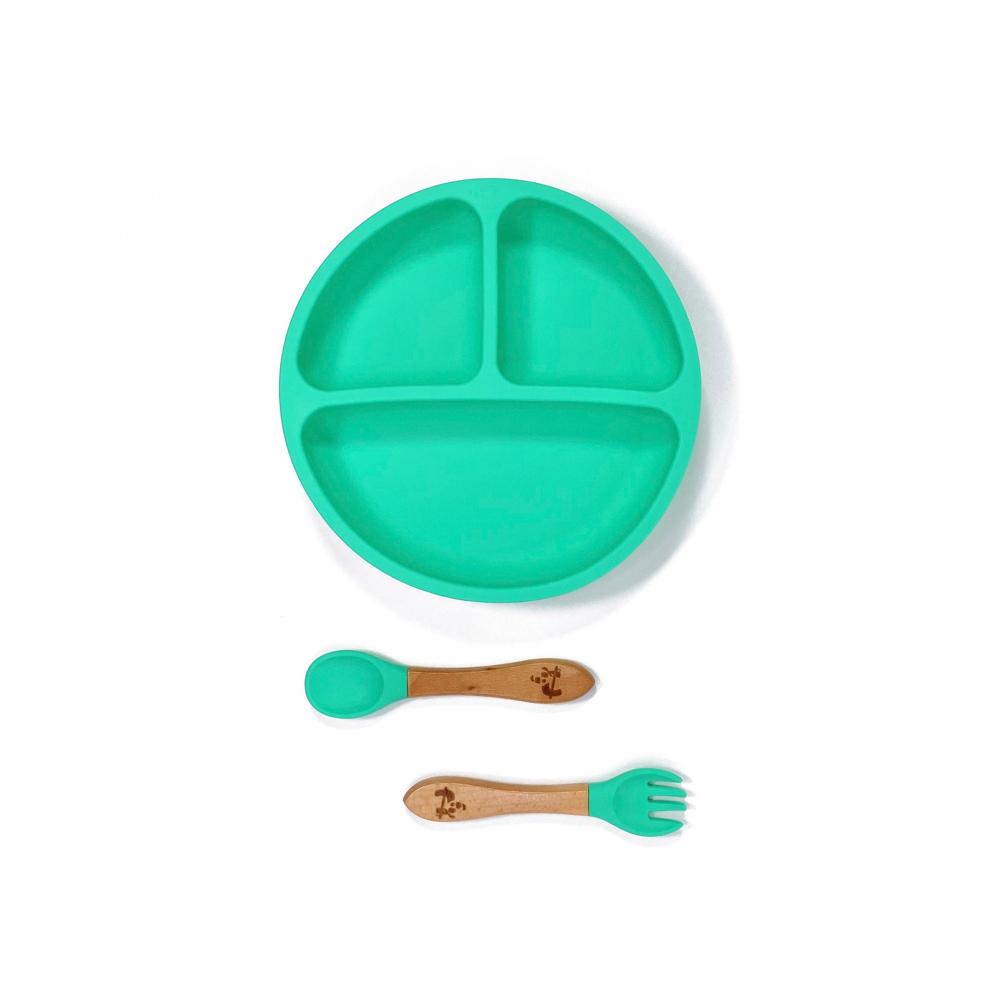 A seafoam green silicone children’s section plate with cups on the base, and matching bamboo and silicone cutlery.