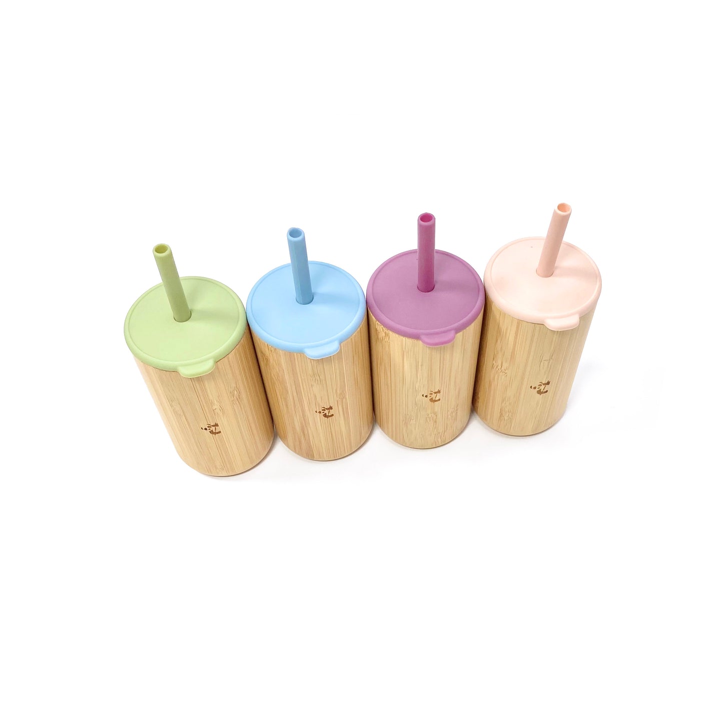 A collection of children’s bamboo drinking cups, with colourful silicone lids and matching straws. View shows the cups from above, arranged in a line diagonally, displaying the silicone lids and straws. 