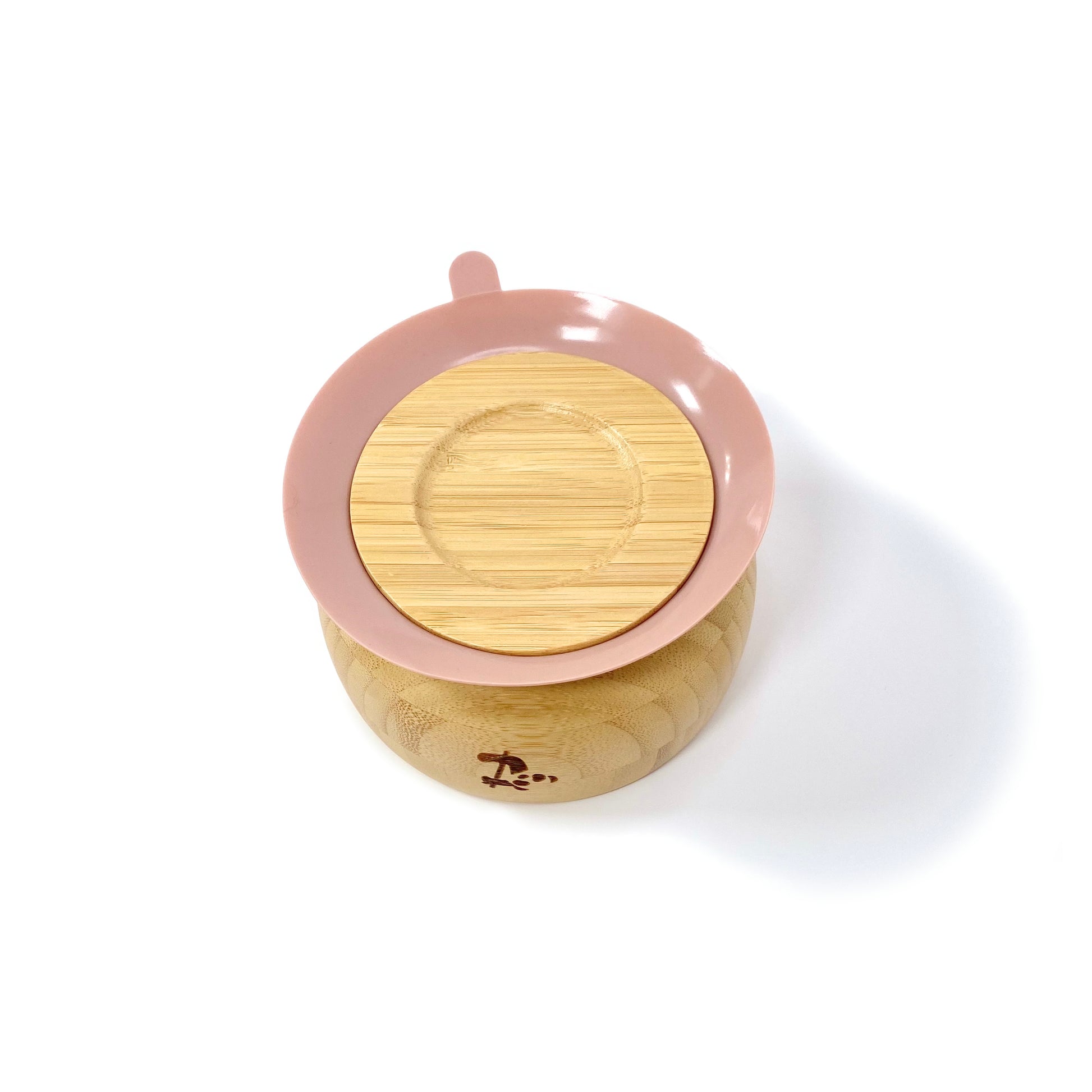 A children’s bamboo bowl with a blossom pink silicone suction ring. Image shows the underside of the bowl, featuring the silicone suction ring.