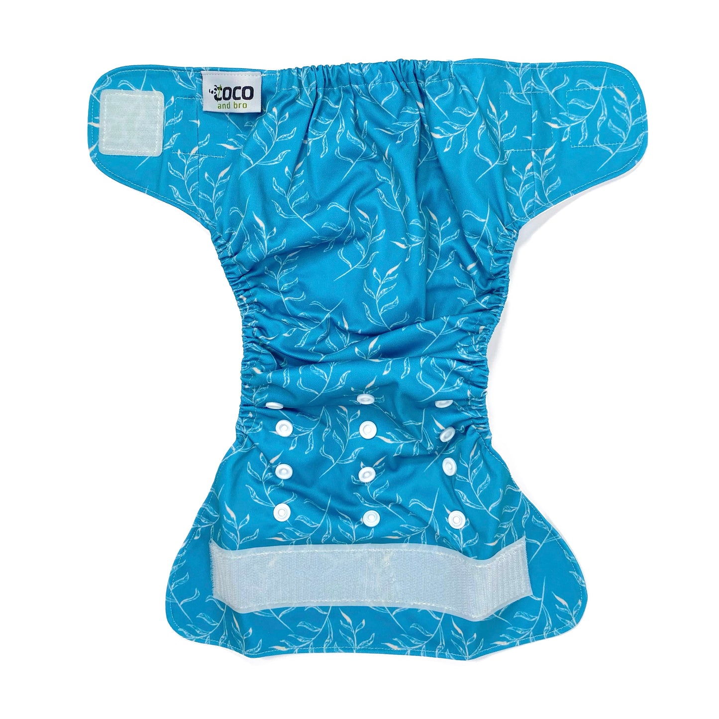 An adjustable reusable nappy for babies and toddlers, featuring a blue fern design, with images of white fern leaves on a blue background. View shows the full outside pattern of the nappy, with fastenings open.