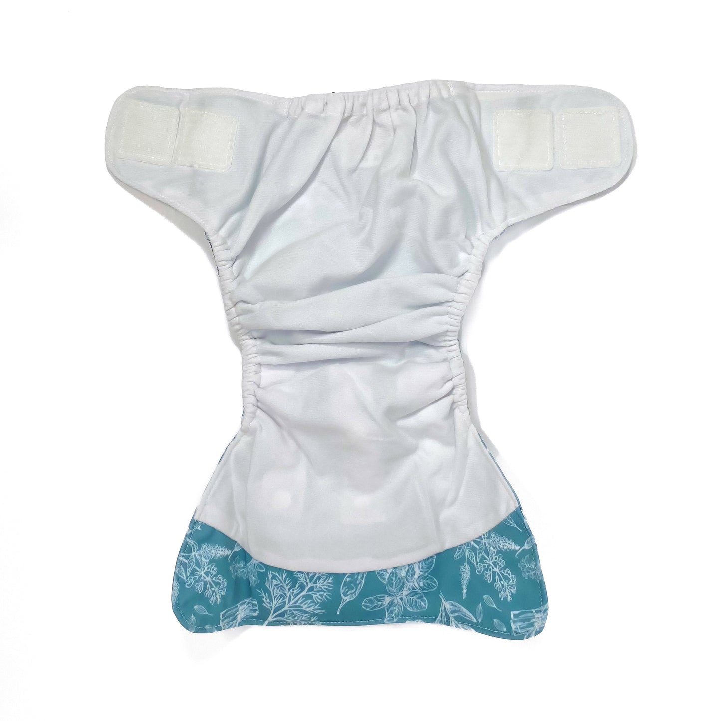 An adjustable reusable nappy for babies and toddlers, featuring a blue harvest design, with white images of various crops on a blue background. View shows the inside fabric of the nappy.