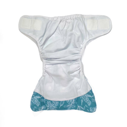 An adjustable reusable nappy for babies and toddlers, featuring a blue harvest design, with white images of various crops on a blue background. View shows the inside fabric of the nappy.