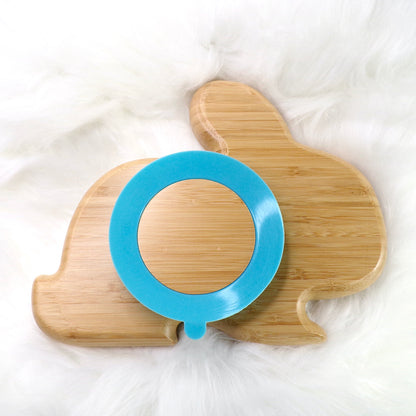 A children's bamboo section plate with a rabbit design, blue colour silicone suction ring and matching blue bamboo and silicone cutlery. Back view.