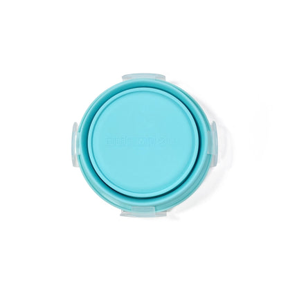 A collapsible blue circular silicone food storage tub with lid. View shows the underside of the tub, with the tub fully collapsed.