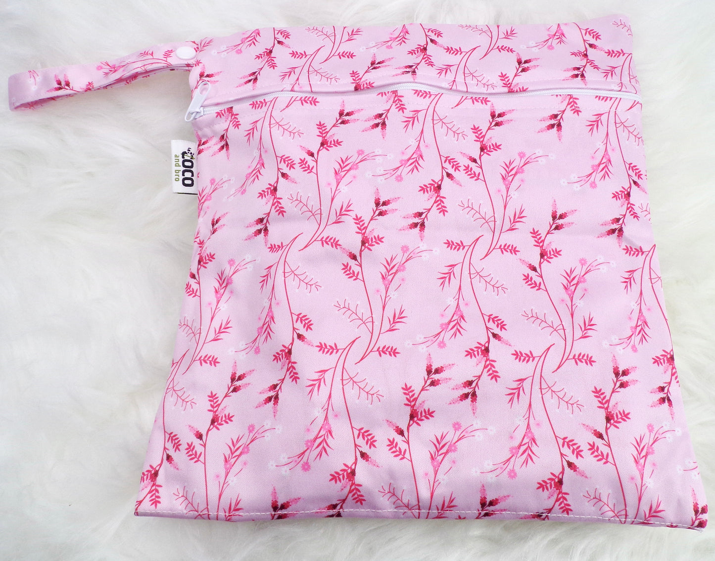 A set of three waterproof bags in a pink floral design, made from bamboo and in three different sizes. Each bag has a zipper closure. Image shown displays the largest bag with the two smaller bags contained within.