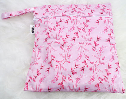 A set of three waterproof bags in a pink floral design, made from bamboo and in three different sizes. Each bag has a zipper closure. Image shown displays the largest bag with the two smaller bags contained within.