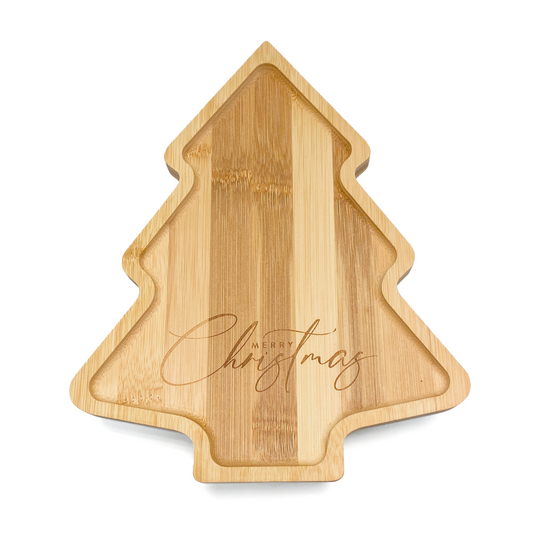 A festive children's bamboo plate in the shape of a Christmas tree. The message 'Merry Christmas’ is engraved into the plate. Image shows the front of the plate.