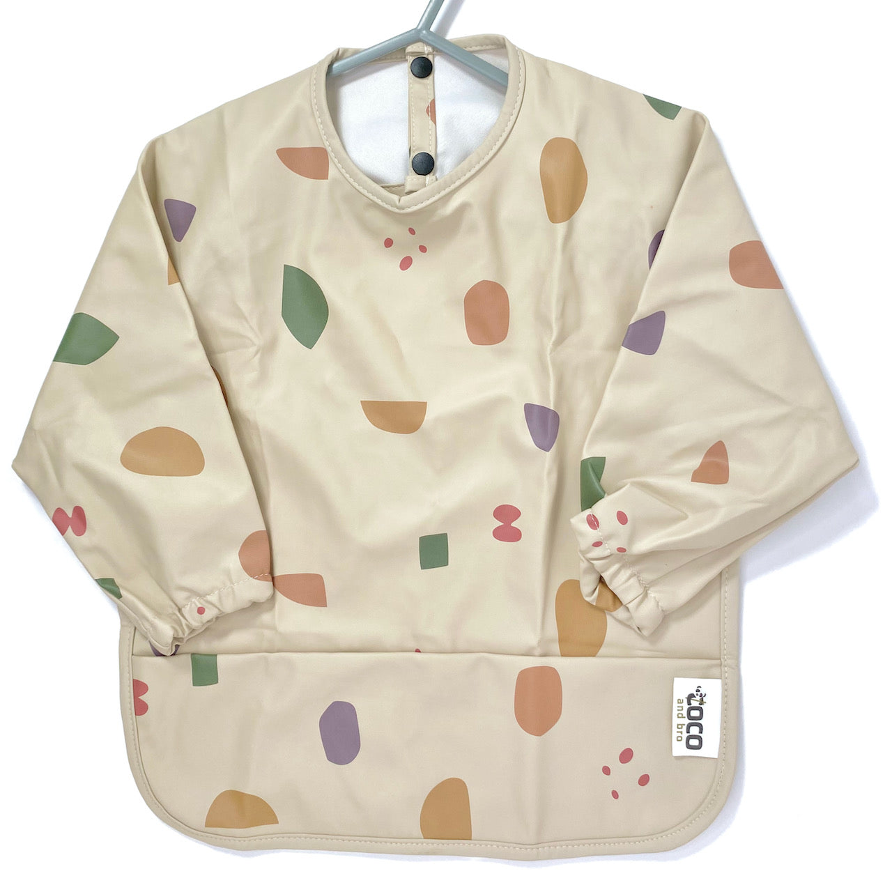 Long-sleeve kids apron in a beige and multicolour design, showing front view.