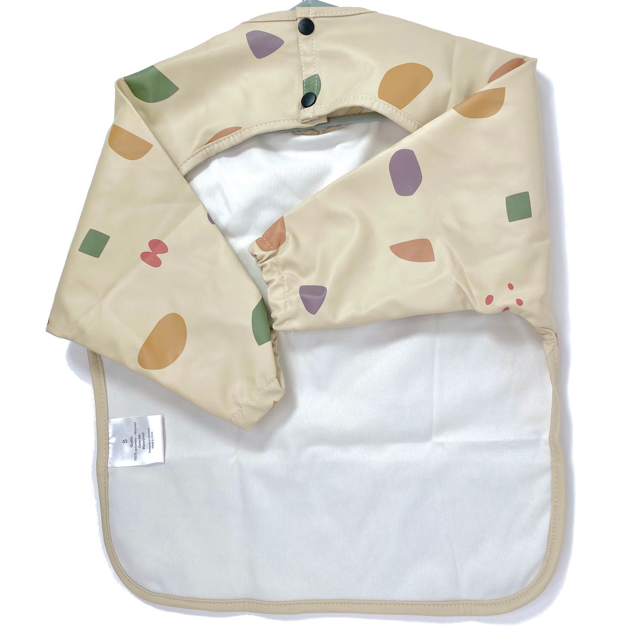 Long-sleeve kids apron in a beige and multicolour design, showing back view.