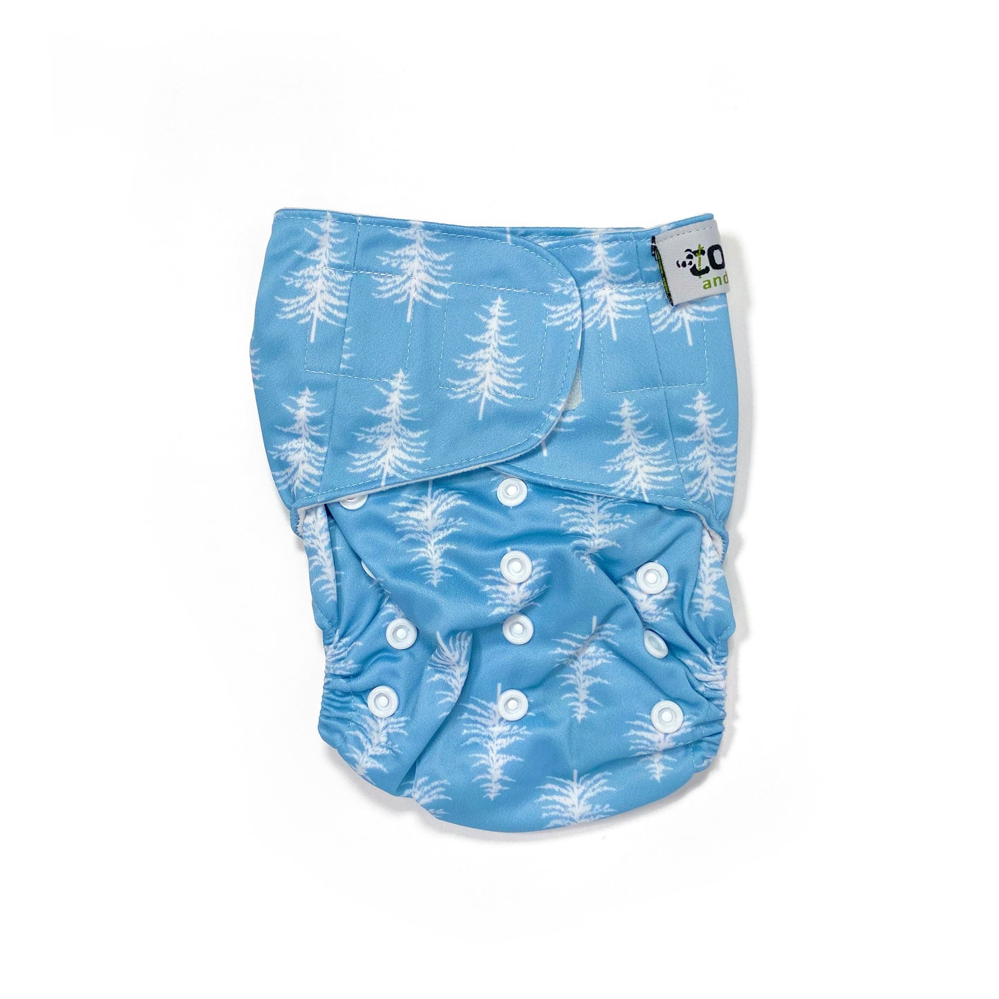 An adjustable reusable nappy for babies and toddlers, featuring a cool blue pine design design, with images of white pine trees on a blue background. View shows the front of the nappy, with fastenings closed.