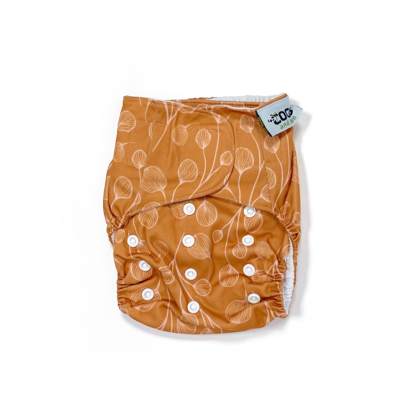 An adjustable reusable nappy for babies and toddlers, featuring a floral copper design, with floral images on a copper background. View shows the front of the nappy, with fastenings closed.