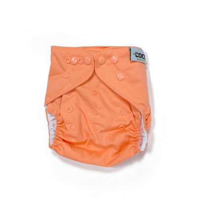 An adjustable reusable nappy for babies and toddlers, in a bright coral colour. View shows the front of the nappy, with fastenings closed.