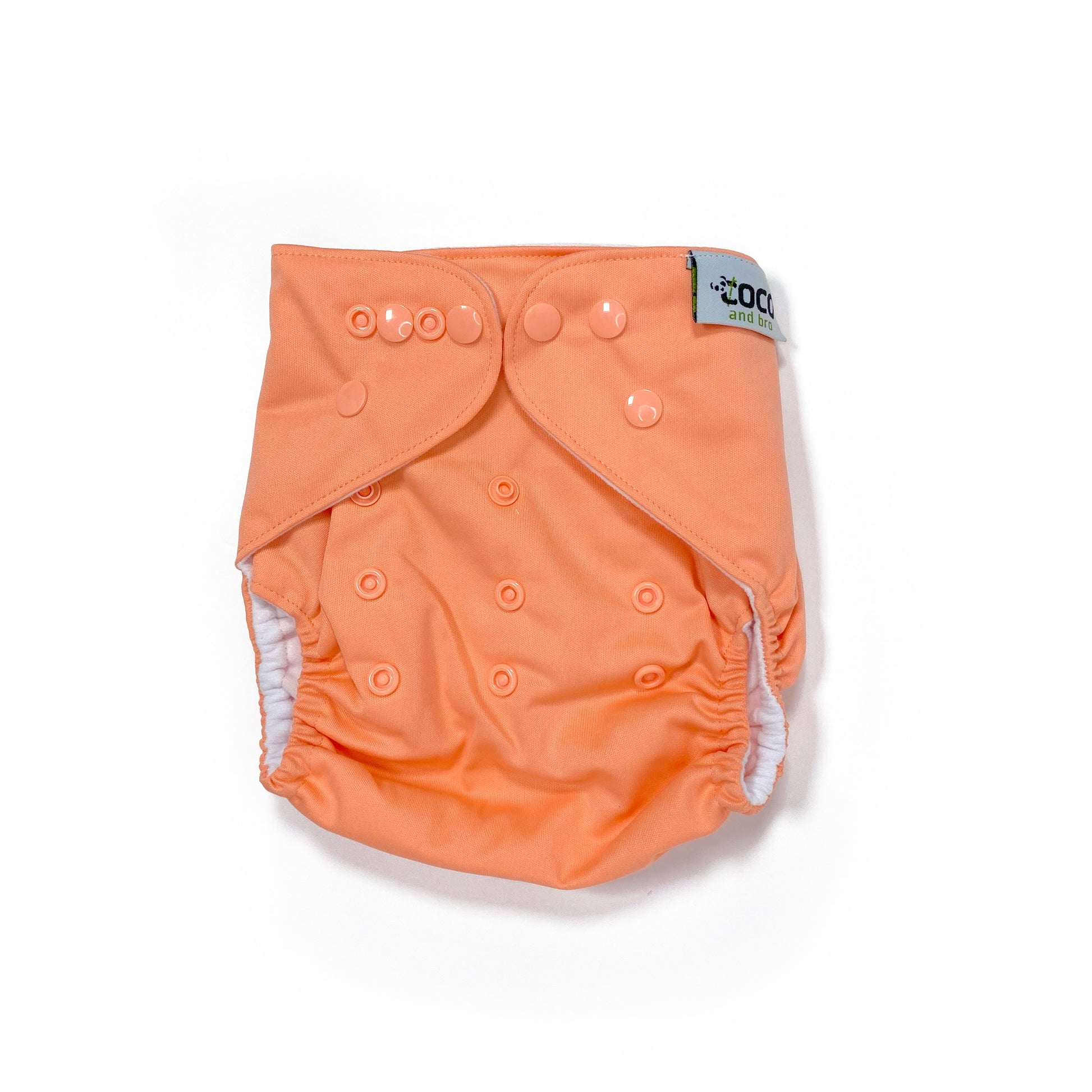An adjustable reusable nappy for babies and toddlers, in a bright coral colour. View shows the front of the nappy.