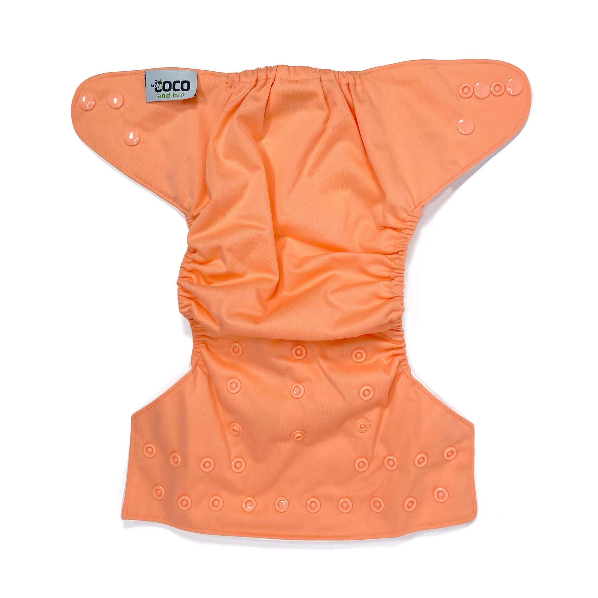 An adjustable reusable nappy for babies and toddlers, in a bright coral colour. View shows the full outside pattern of the nappy, with fastenings open.