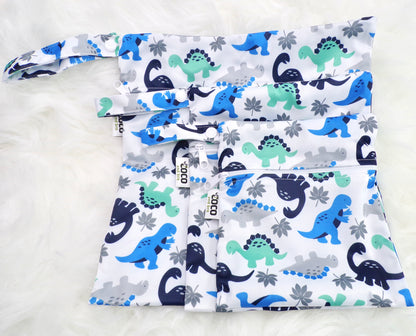 A set of three waterproof bags in a green and blue dinosaur design on a white background, made from bamboo and in three different sizes. Each bag has a zipper closure.