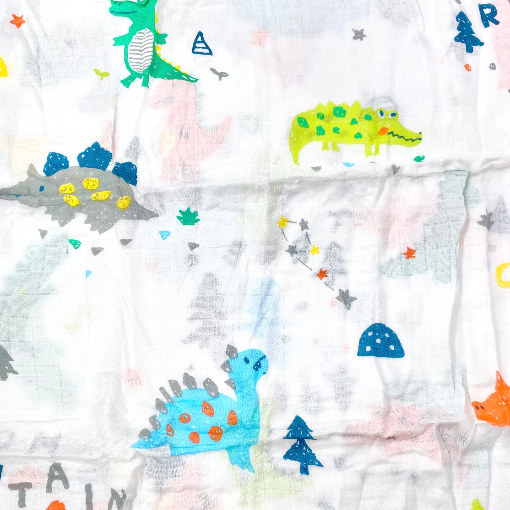 Close up pattern of a muslin swaddle blanket with dinosaur crocodile design.