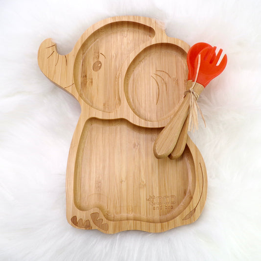 A children's bamboo section plate with an elephant design, orange colour silicone suction ring and matching orange bamboo and silicone cutlery. Front view.