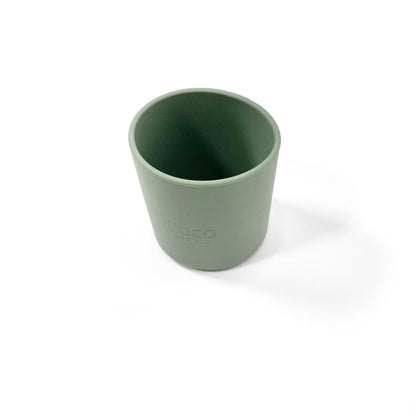 A forest green silicone children’s drinking cup. View from above.