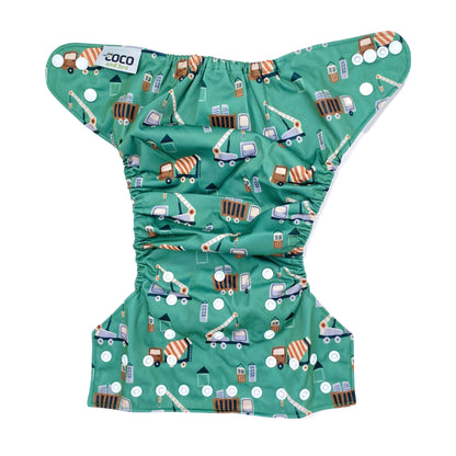 An adjustable reusable nappy for babies and toddlers, featuring a green construction design, with images of construction vehicles on a green background. View shows the full outside pattern of the nappy, with fastenings open.