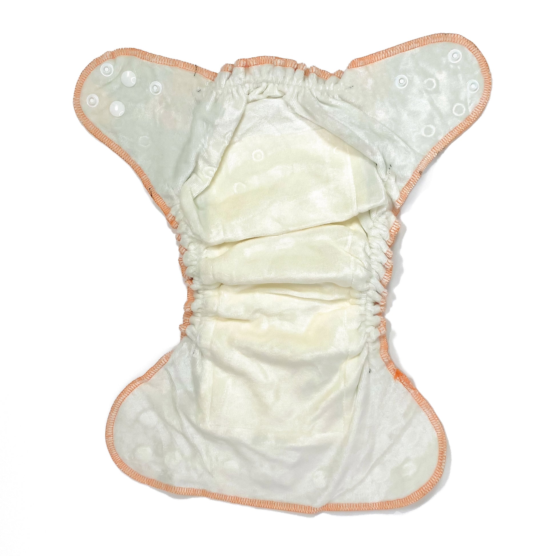 An adjustable reusable nappy for babies and toddlers, featuring a green fox design, with images of foxes on a green background. View shows the inside fabric of the nappy.
