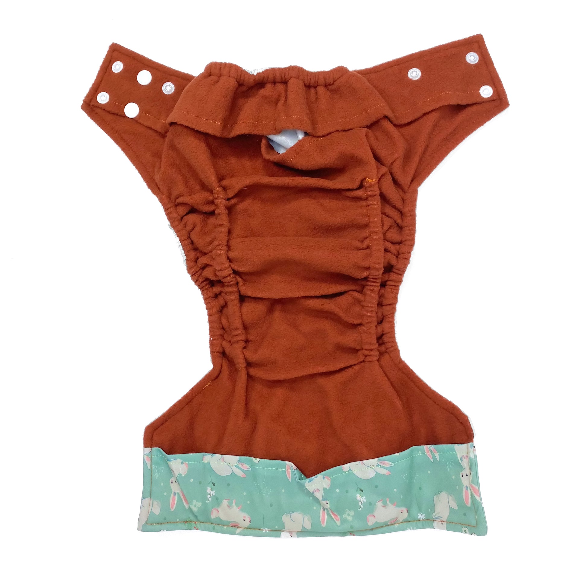 An adjustable reusable nappy for babies and toddlers, featuring a green rabbits design, with images of grey rabbits on a green background. View shows the inside fabric of the nappy.