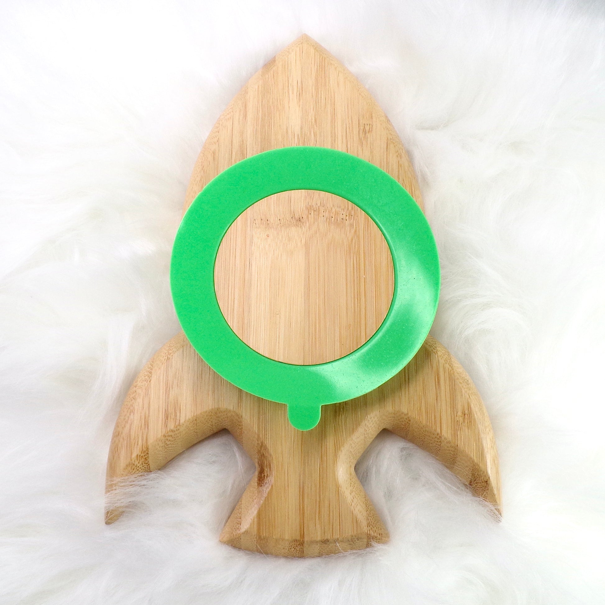 A children's bamboo section plate with a rocket design, green colour silicone suction ring and matching green bamboo and silicone cutlery. Back view.