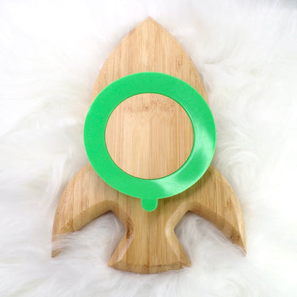 A children's bamboo section plate with a rocket design, green colour silicone suction ring and matching green bamboo and silicone cutlery. Back view.