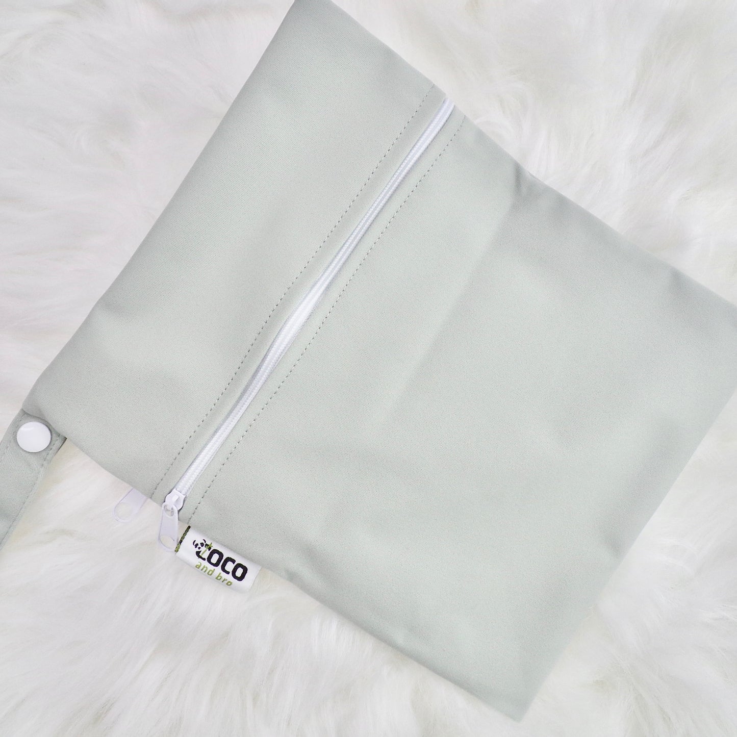 Each backpack purchase includes a free waterproof bag. This image shows the waterproof bag in grey, with a zip closure.