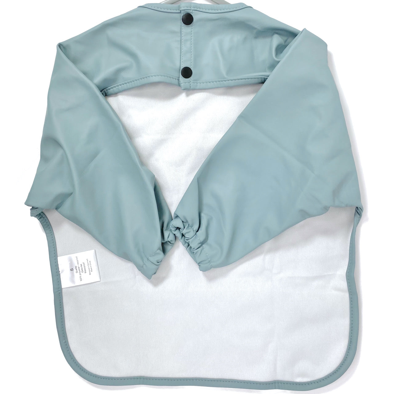 Long-sleeve kids apron in an ice blue colour, showing back view.