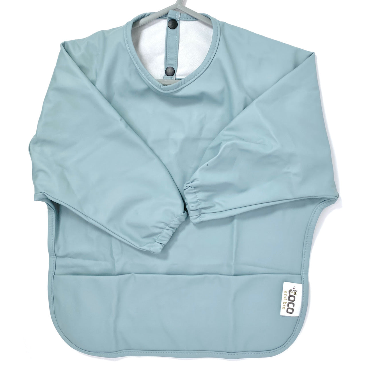 Long-sleeve kids apron in an ice blue colour, showing front view.