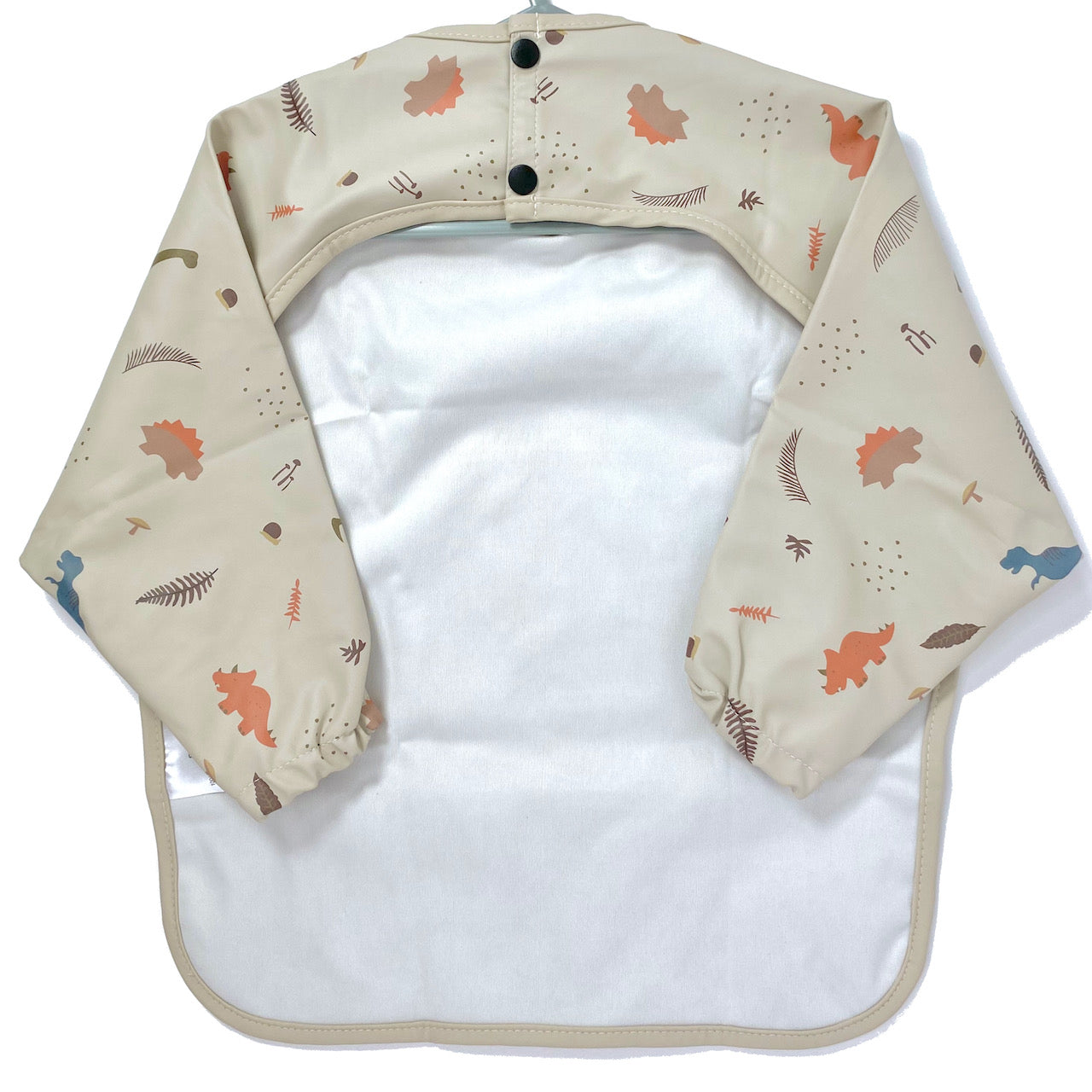 Long-sleeve kids apron in a beige and dinosaur design, showing back view.
