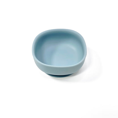 An ocean blue silicone children’s feeding bowl with suction cup on the base. Side view.