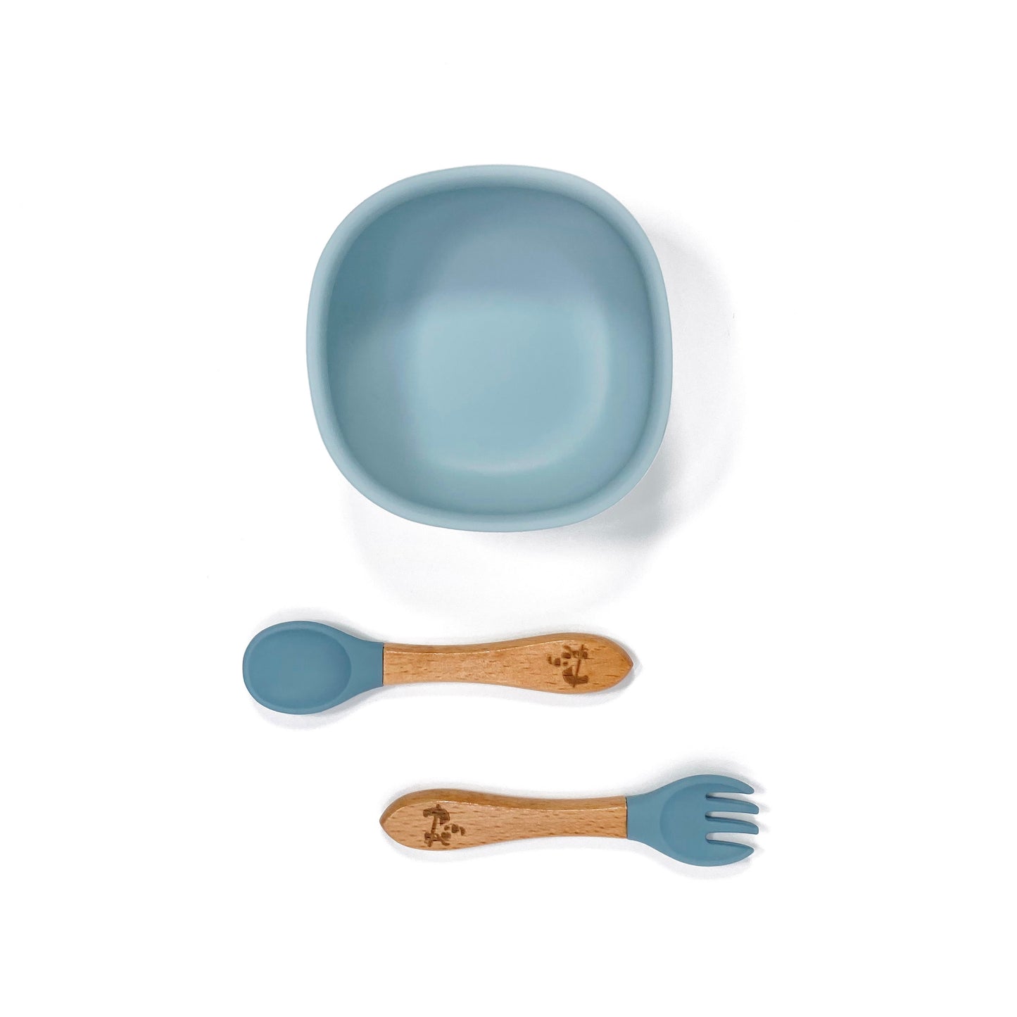 An ocean blue silicone children’s feeding bowl, with matching bamboo and silicone cutlery.