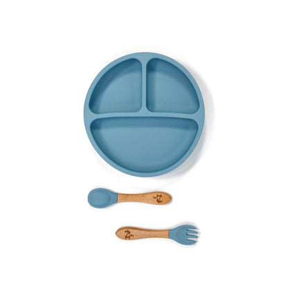 An ocean blue silicone children’s section plate with cups on the base, and matching bamboo and silicone cutlery.