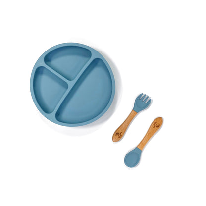 An ocean blue silicone children’s section plate with cups on the base, and matching bamboo and silicone cutlery.