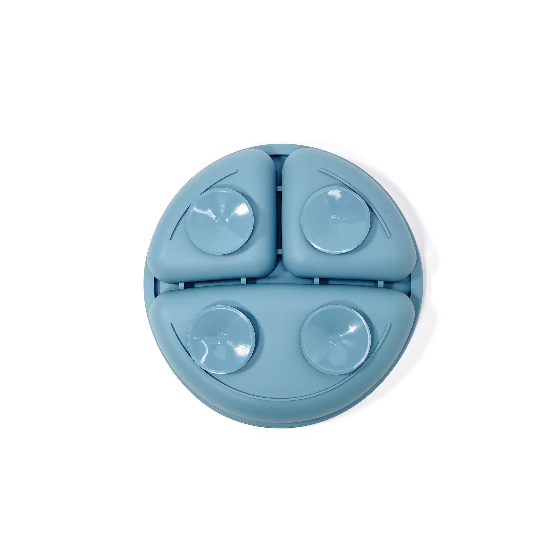 An ocean blue silicone children’s section plate with suction cups on the base. View shows the underside of the plate.
