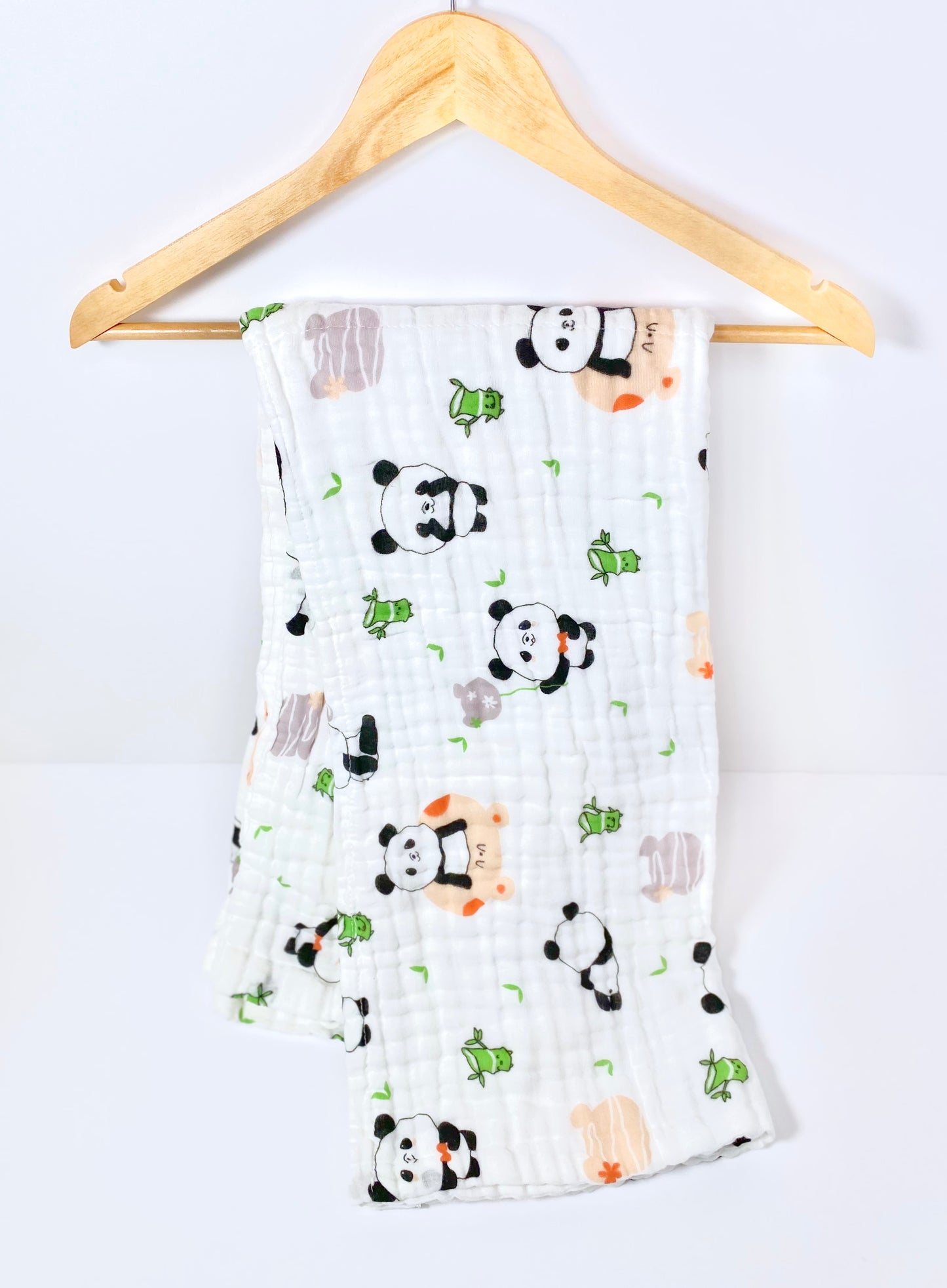 A muslin baby buggy blanket made from bamboo and cotton fibres, in a panda design. 