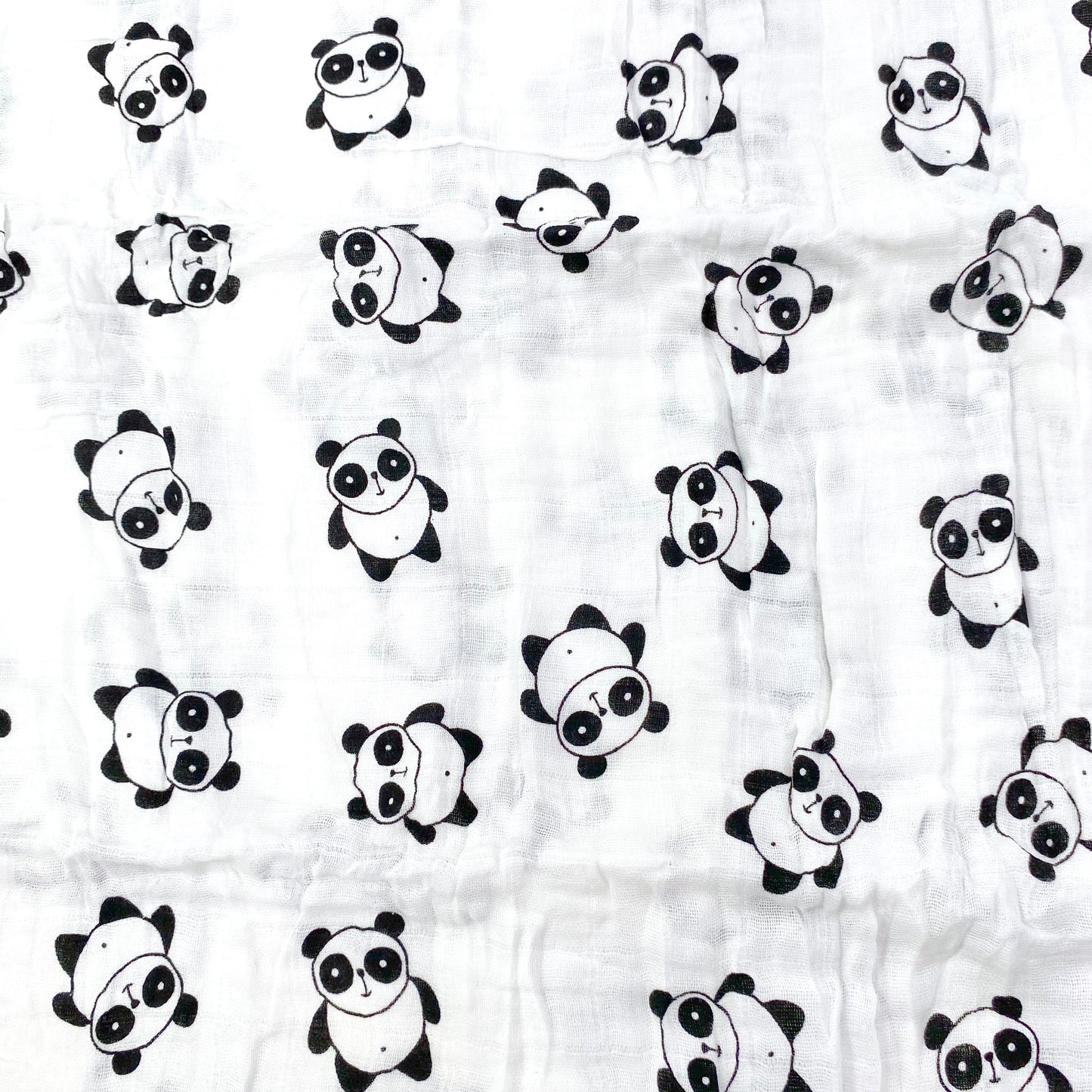 Close up pattern of a muslin swaddle blanket with a panda design.