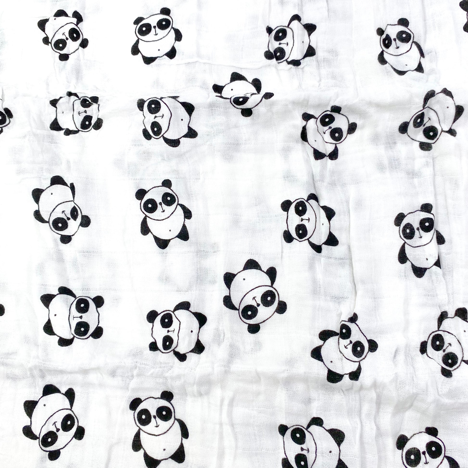 A close up view of the panda pattern of a muslin baby blanket.