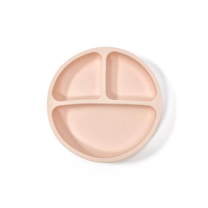 A peachy pink silicone children’s section plate with suction cups on the base. View from above.