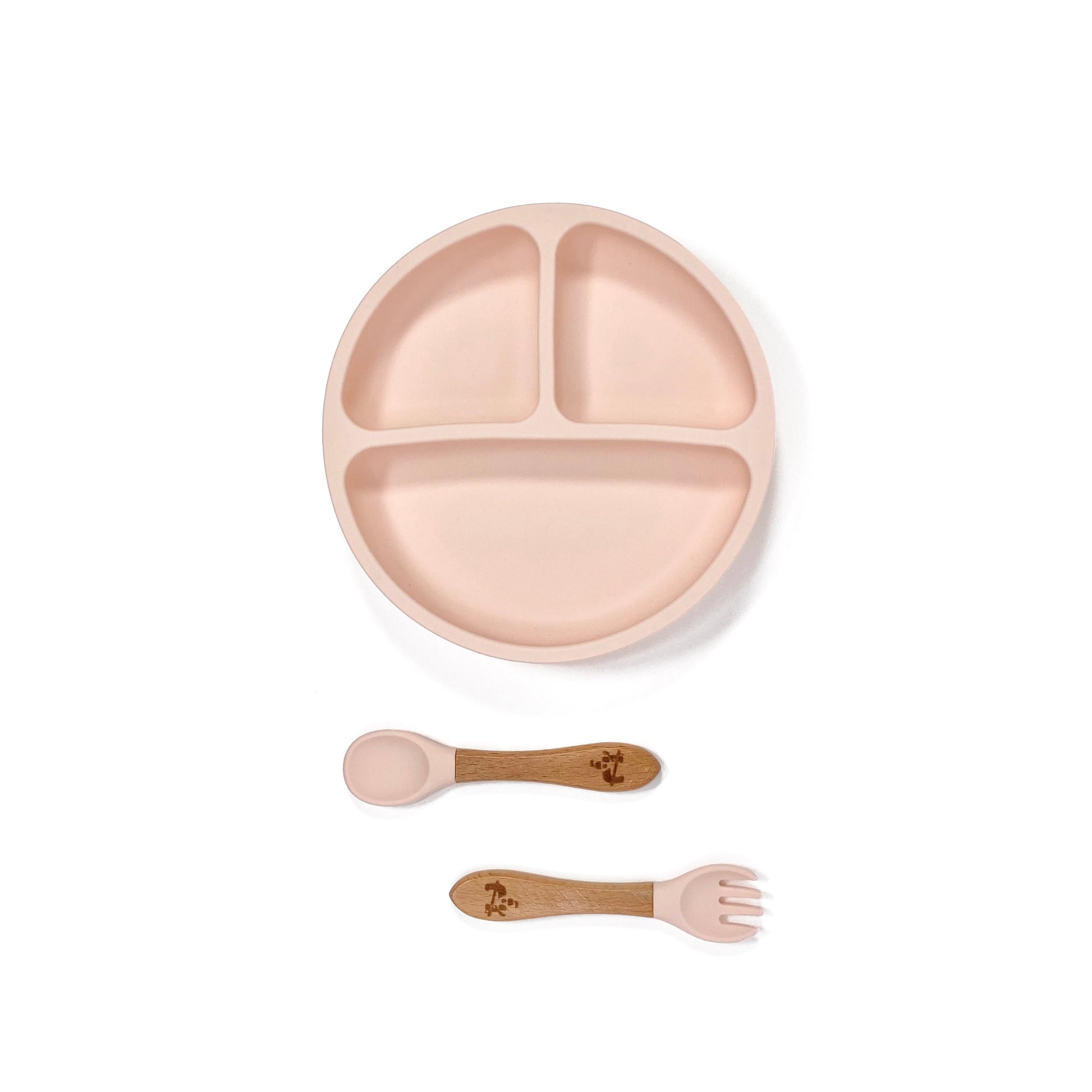A peachy pink silicone children’s section plate with cups on the base, and matching bamboo and silicone cutlery.