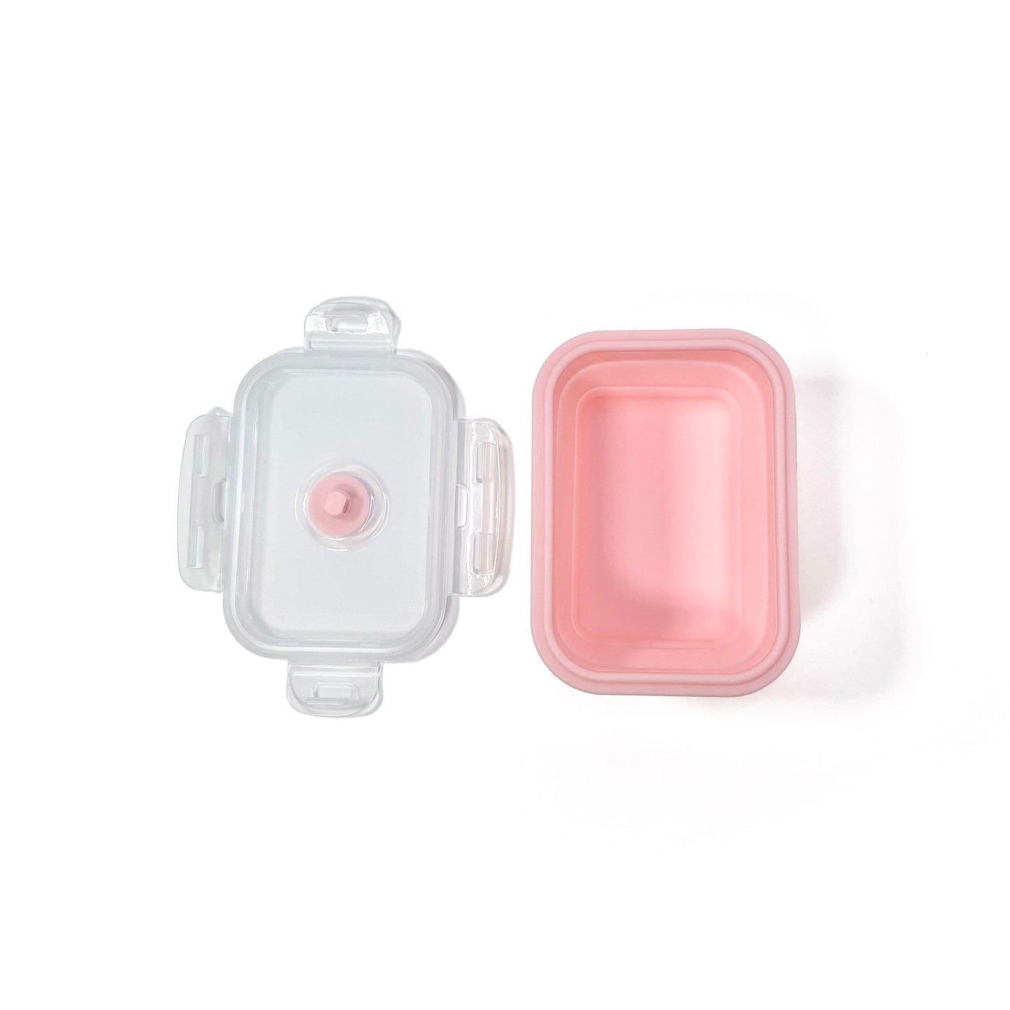 A collapsible pink rectangular silicone food storage tub with lid. View from above, with the tub expanded to full size and lid removed.