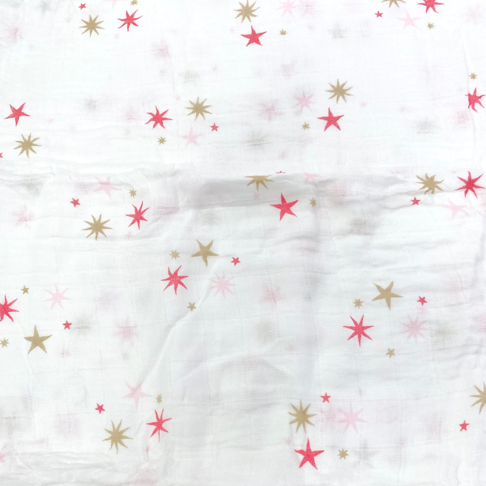 Close up pattern of a muslin swaddle blanket with a pink stars design.