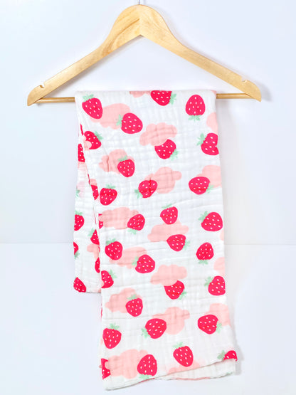 A muslin baby buggy blanket made from bamboo and cotton fibres, in a pink strawberry design.