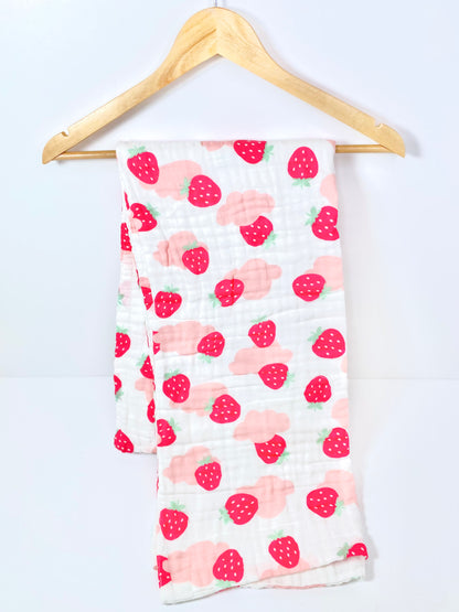 A muslin baby buggy blanket made from bamboo and cotton fibres, in a pink strawberry design.